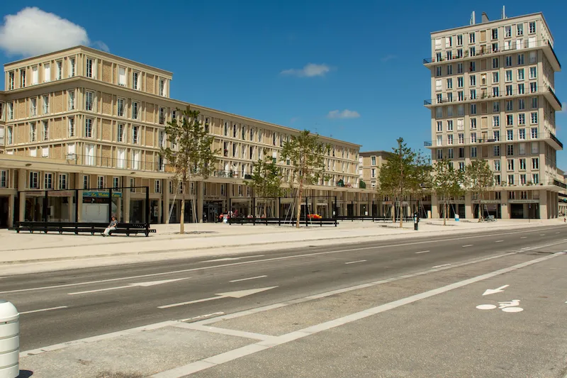 Perspectives et lignes droites des façades en béton clair d'Auguste Perret au Havre, illustrant la structure et la reconstruction.