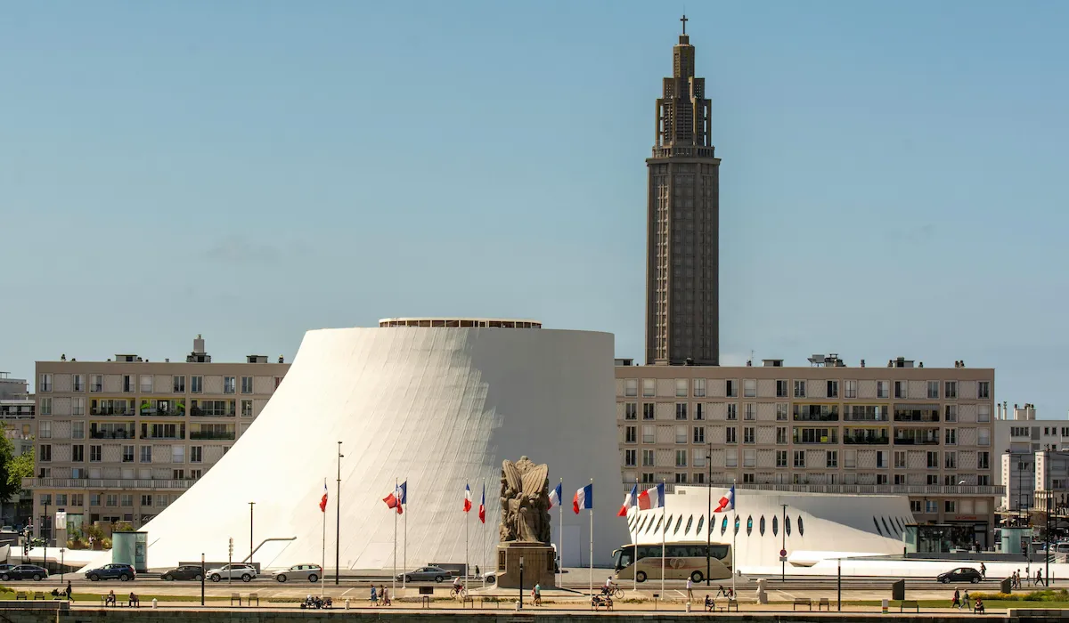 Le Volcan blanc d'Oscar Niemeyer et l'église Saint-Joseph au Havre, symboles d'architecture épurée et de reconstruction après une épreuve.